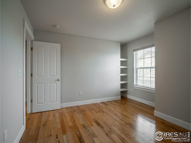 2946 Shoshone Trl, Lafayette, CO 80026 - empty room with light wood-style flooring, built in features, and a smoke detector