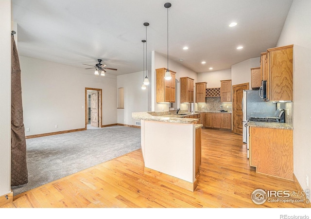 20199 Leola Way, Eaton, CO 80615 - kitchen with a ceiling fan, appliances with stainless steel finishes, light wood finished floors, pendant lighting, and open floor plan
