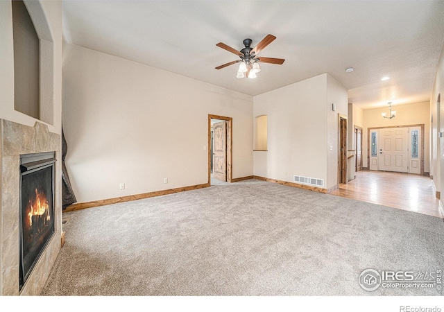 20199 Leola Way, Eaton, CO 80615 - unfurnished living room featuring carpet flooring, a lit fireplace, and ceiling fan