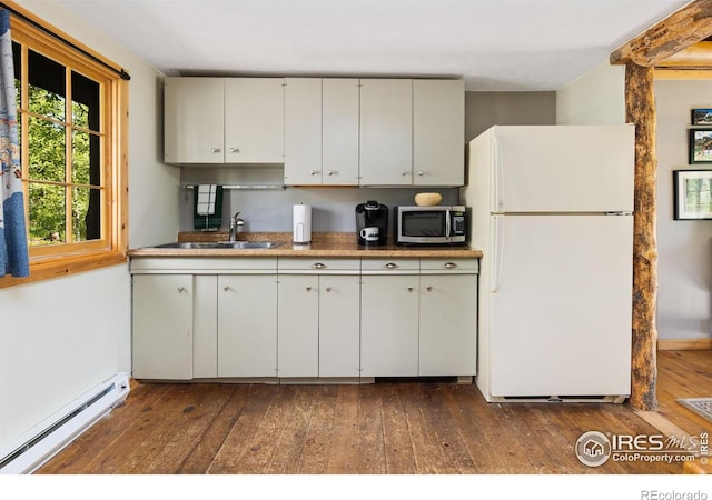 11614 Peak To Peak Hwy, Allenspark, CO 80510 - kitchen with freestanding refrigerator, a baseboard heating unit, stainless steel microwave, dark wood finished floors, and white cabinetry