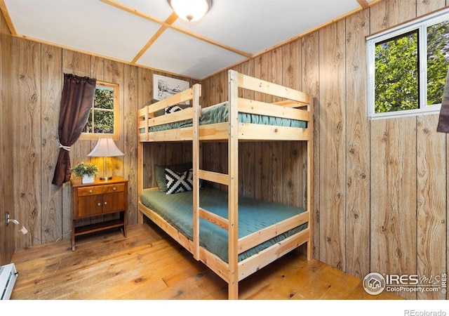 11614 Peak To Peak Hwy, Allenspark, CO 80510 - bedroom with wood walls, multiple windows, hardwood / wood-style flooring, and a baseboard radiator