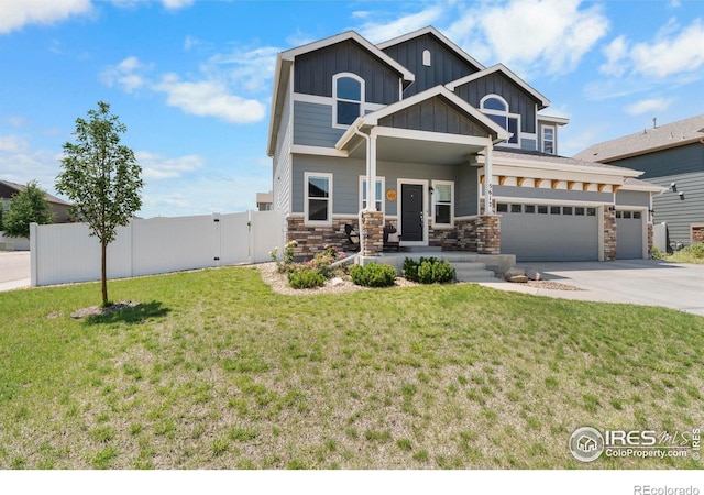 5612 Osbourne Dr, Windsor, CO 80550 - craftsman-style home with board and batten siding, stone siding, a gate, covered porch, and concrete driveway