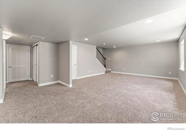 5612 Osbourne Dr, Windsor, CO 80550 - below grade area featuring a textured ceiling, carpet flooring, stairs, and recessed lighting