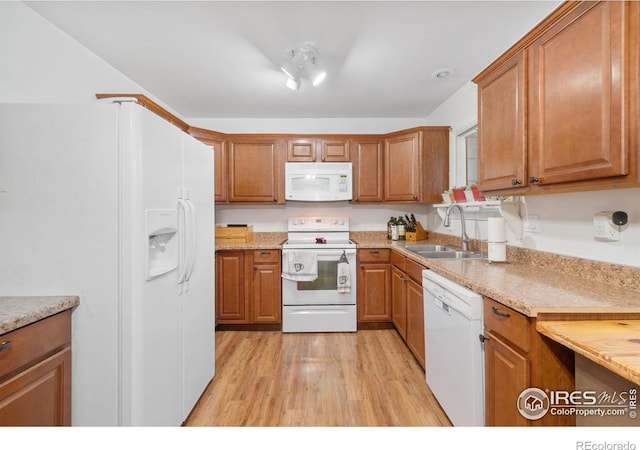3920 Windom St, Fort Collins, CO 80526 - kitchen with white appliances, light wood-style flooring, and brown cabinets