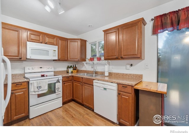 3920 Windom St, Fort Collins, CO 80526 - kitchen with white appliances, brown cabinetry, light countertops, and light wood finished floors