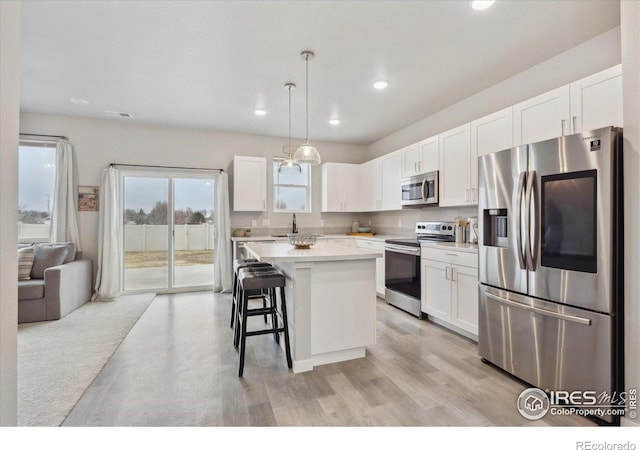 362 Bozeman Trl, Ault, CO 80610 - kitchen featuring stainless steel appliances, light countertops, white cabinetry, a center island, and recessed lighting