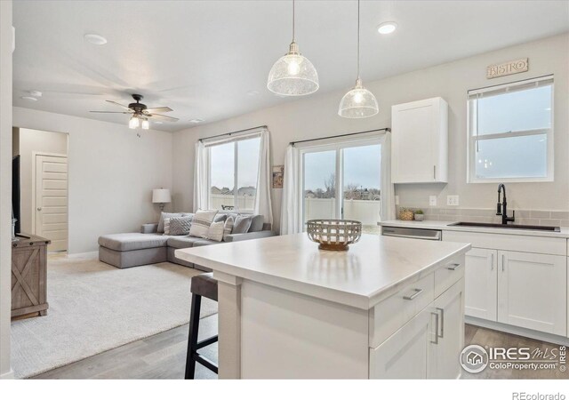 362 Bozeman Trl, Ault, CO 80610 - kitchen with ceiling fan, a center island, white cabinets, light wood finished floors, and recessed lighting