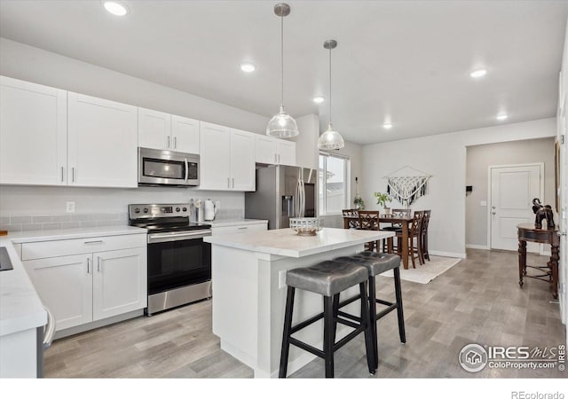 362 Bozeman Trl, Ault, CO 80610 - kitchen with stainless steel appliances, light countertops, light wood finished floors, white cabinets, and recessed lighting