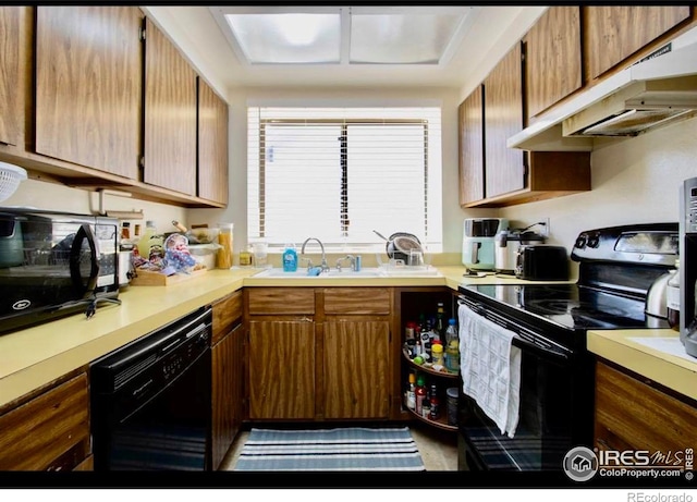 1325 Birch St Unit 12, Fort Collins, CO 80521 - kitchen with black appliances, under cabinet range hood, light countertops, and brown cabinets