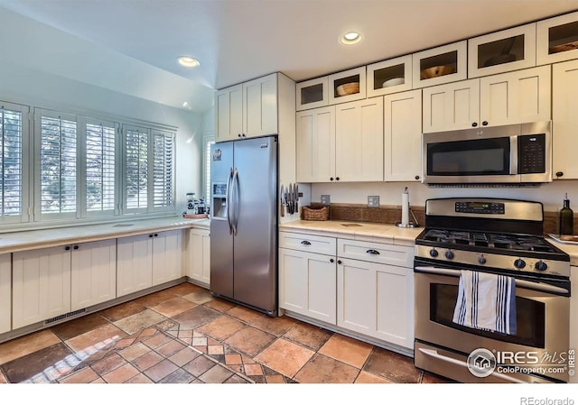 1149 Quince Ave, Boulder, CO 80304 - kitchen featuring stainless steel appliances, stone tile flooring, recessed lighting, glass insert cabinets, and white cabinetry
