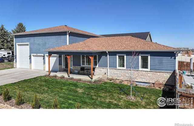 1403 Crestridge Dr, Loveland, CO 80537 - view of front of house with concrete driveway, a porch, a front yard, an attached garage, and stone siding
