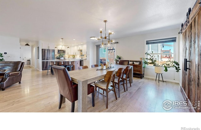 1403 Crestridge Dr, Loveland, CO 80537 - dining space featuring a chandelier, light wood-type flooring, and a barn door