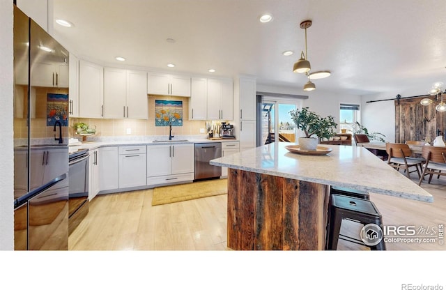 1403 Crestridge Dr, Loveland, CO 80537 - kitchen with freestanding refrigerator, stainless steel dishwasher, white cabinetry, light wood-type flooring, and recessed lighting