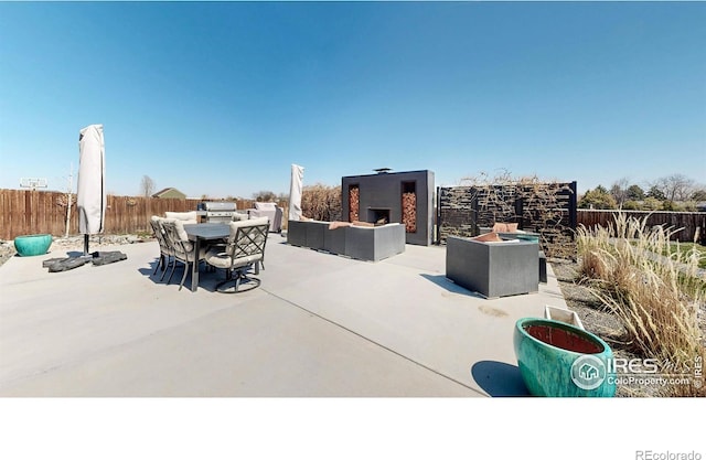 1403 Crestridge Dr, Loveland, CO 80537 - fenced backyard featuring a patio area, an outdoor living space with a fireplace, and outdoor dining area