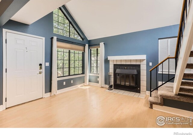 5918 Gunbarrel Ave Unit B, Boulder, CO 80301 - foyer entrance featuring wood finished floors, a tile fireplace, stairway, and high vaulted ceiling