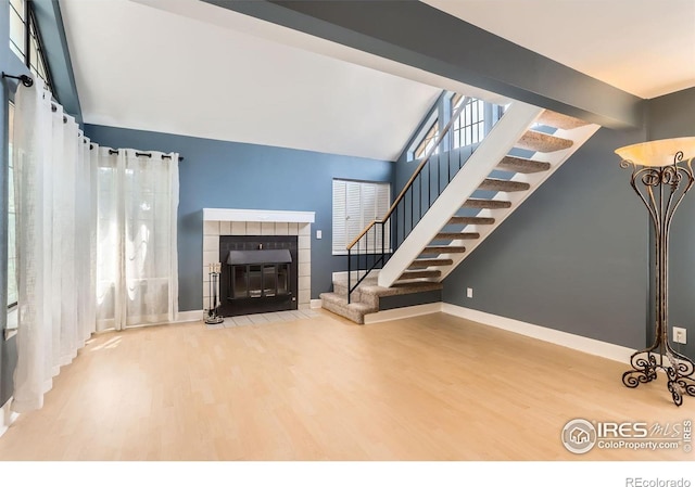 5918 Gunbarrel Ave Unit B, Boulder, CO 80301 - unfurnished living room featuring stairway, wood finished floors, a tile fireplace, and vaulted ceiling