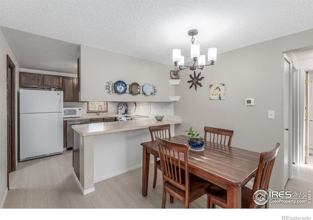 2707 W Stuart St, Fort Collins, CO 80526 - dining space featuring a chandelier, a textured ceiling, and light wood finished floors