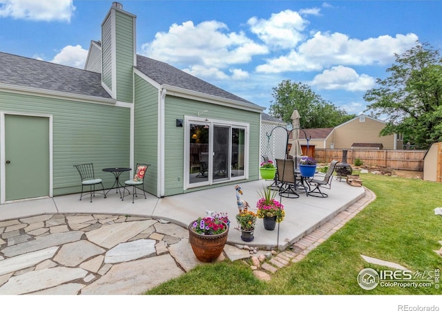 2707 W Stuart St, Fort Collins, CO 80526 - rear view of house featuring a patio, a chimney, and a shingled roof