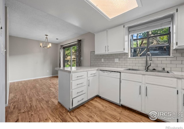 2840 W 21st St Unit 7, Greeley, CO 80634 - kitchen featuring dishwasher, a peninsula, white cabinets, and a textured ceiling