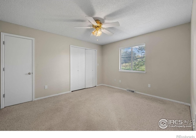 2840 W 21st St Unit 7, Greeley, CO 80634 - unfurnished bedroom with carpet flooring, a textured ceiling, a ceiling fan, and a closet