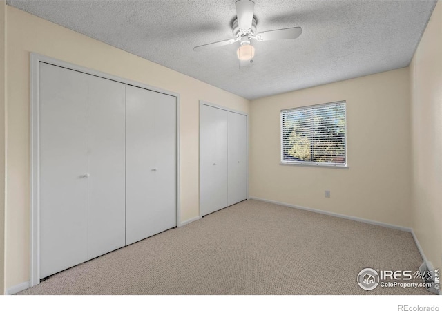 2840 W 21st St Unit 7, Greeley, CO 80634 - unfurnished bedroom with two closets, carpet flooring, a textured ceiling, and a ceiling fan