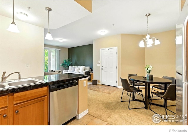 2450 Windrow Dr Unit E106, Fort Collins, CO 80525 - kitchen with appliances with stainless steel finishes, light carpet, tile counters, brown cabinetry, and pendant lighting