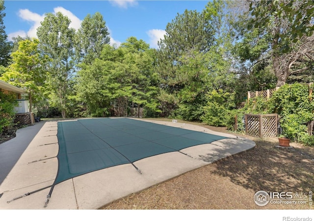 1323 Horizon Ln, Longmont, CO 80501 - view of pool featuring a patio area, a covered pool, and view of wooded area