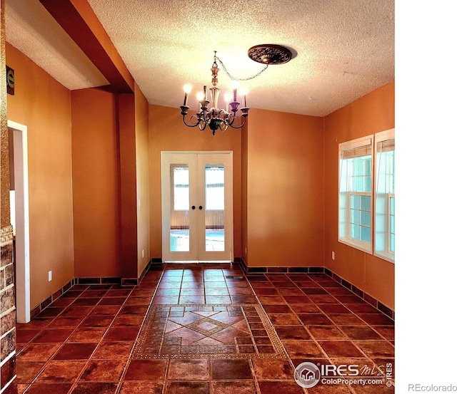 18082 County Road 25, Brush, CO 80723 - spare room with plenty of natural light, a textured ceiling, french doors, and a chandelier