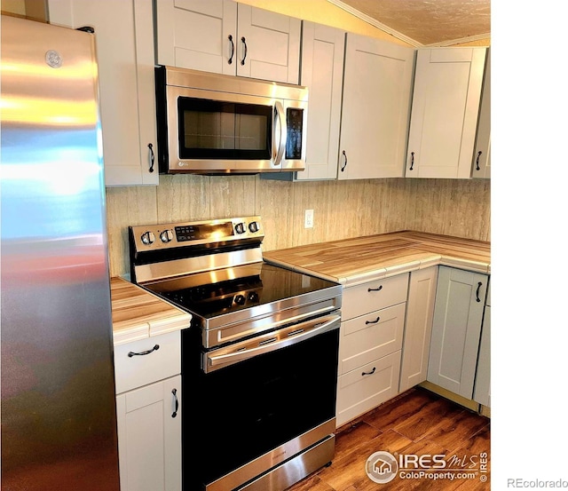 18082 County Road 25, Brush, CO 80723 - kitchen featuring appliances with stainless steel finishes, butcher block countertops, dark wood-style floors, and decorative backsplash