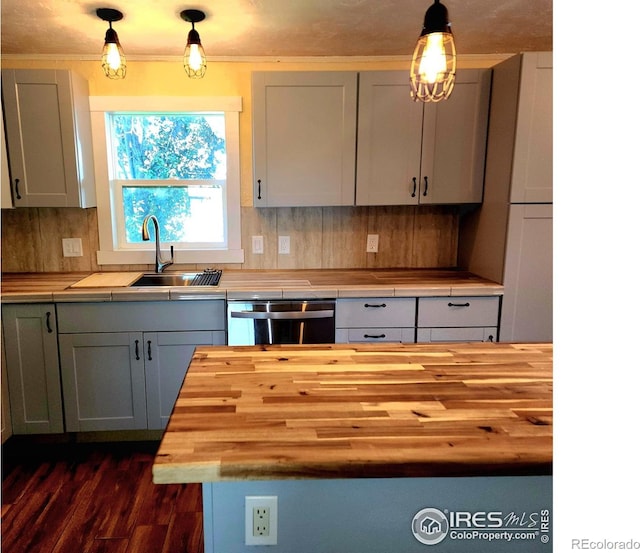 18082 County Road 25, Brush, CO 80723 - kitchen with wood counters, dishwasher, tasteful backsplash, dark wood-style flooring, and hanging light fixtures