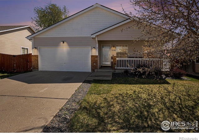 3536 38th Ave, Evans, CO 80620 - view of front of property featuring a garage, covered porch, driveway, and brick siding