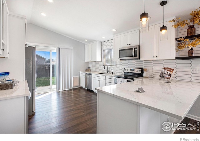 3536 38th Ave, Evans, CO 80620 - kitchen with stainless steel appliances, white cabinetry, lofted ceiling, decorative backsplash, and a peninsula