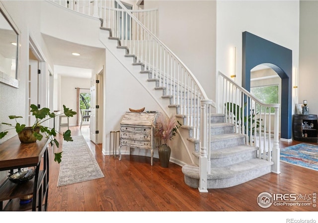 345 Onyx Way, Superior, CO 80027 - staircase featuring a towering ceiling, wood finished floors, and arched walkways