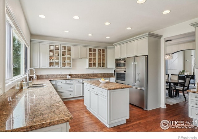 345 Onyx Way, Superior, CO 80027 - kitchen with stainless steel appliances, recessed lighting, light stone counters, a center island, and wood finished floors