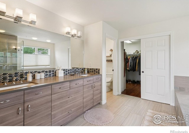345 Onyx Way, Superior, CO 80027 - bathroom with double vanity, a stall shower, a spacious closet, and decorative backsplash