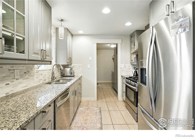 1217 Sycamore St, Fort Collins, CO 80521 - kitchen featuring appliances with stainless steel finishes, backsplash, light stone countertops, glass insert cabinets, and recessed lighting