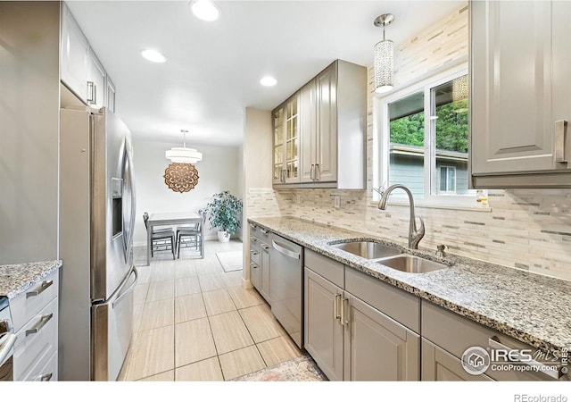 1217 Sycamore St, Fort Collins, CO 80521 - kitchen featuring stainless steel appliances, tasteful backsplash, light tile patterned floors, glass insert cabinets, and hanging light fixtures