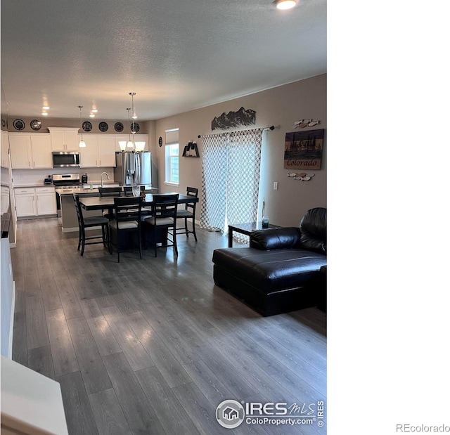 117 N 66th Ave, Greeley, CO 80634 - living area featuring dark wood-type flooring and a chandelier