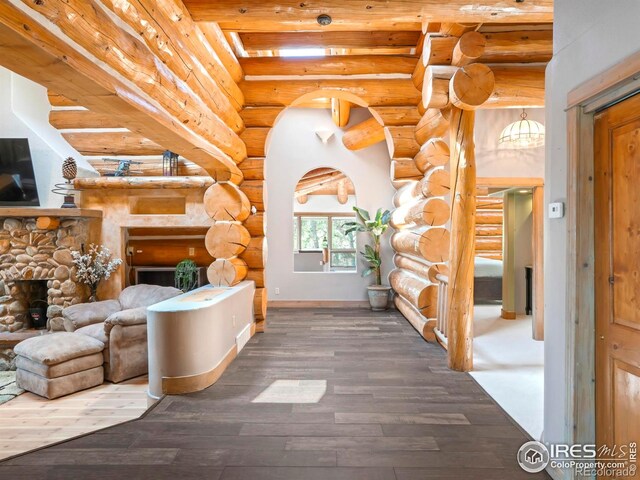 24043 Eagle Cliff Trl, Conifer, CO 80433 - living area featuring a fireplace, log walls, wood finished floors, and beam ceiling