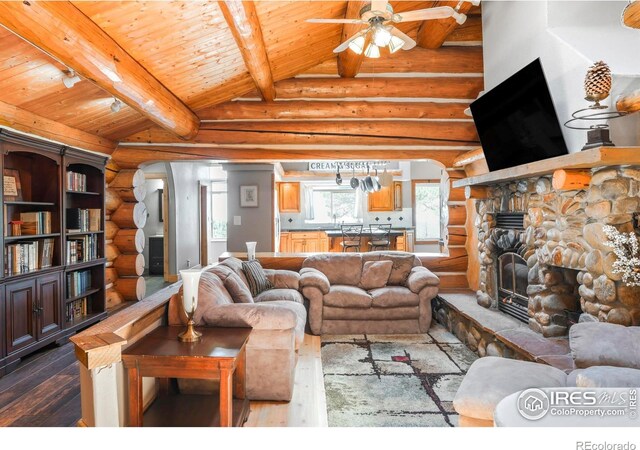 24043 Eagle Cliff Trl, Conifer, CO 80433 - living room with dark wood-style flooring, arched walkways, rustic walls, a ceiling fan, and wood ceiling