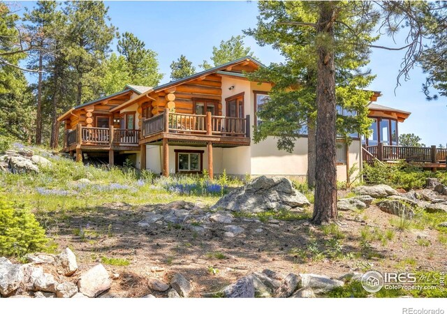 24043 Eagle Cliff Trl, Conifer, CO 80433 - back of property featuring a deck, log exterior, and stucco siding