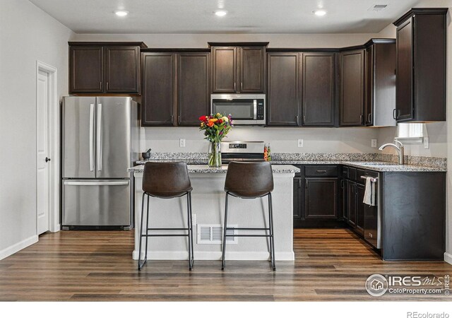 2310 Angus St, Mead, CO 80542 - kitchen featuring stainless steel appliances, dark wood-type flooring, dark brown cabinetry, a kitchen island, and recessed lighting