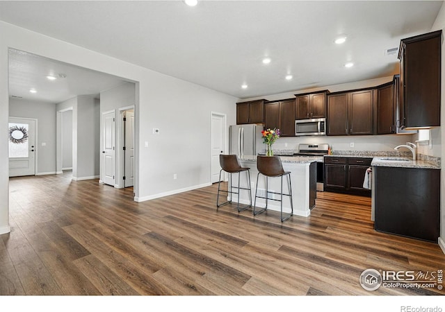 2310 Angus St, Mead, CO 80542 - kitchen featuring stainless steel appliances, a kitchen island, dark brown cabinetry, dark wood finished floors, and recessed lighting