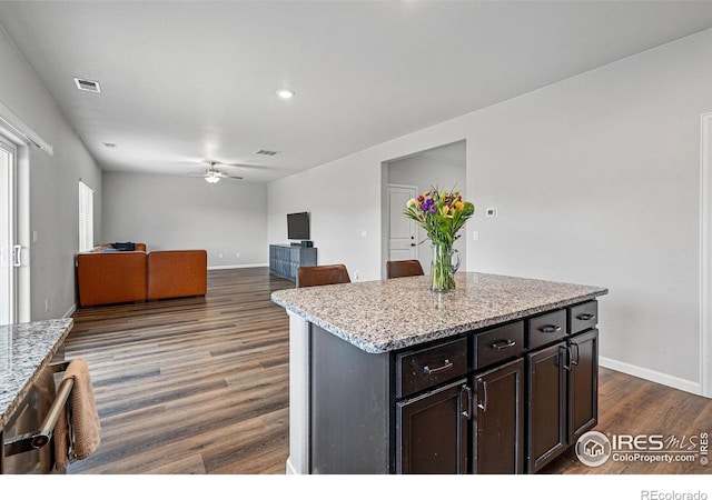 2310 Angus St, Mead, CO 80542 - kitchen featuring ceiling fan, dark wood-style flooring, light stone countertops, a center island, and recessed lighting