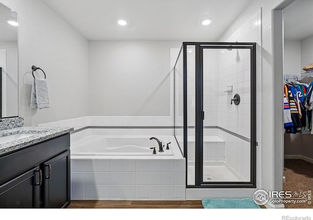 2310 Angus St, Mead, CO 80542 - bathroom with a bath, a stall shower, vanity, a walk in closet, and recessed lighting