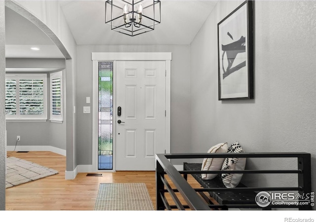 2384 Ponderosa Pl, Erie, CO 80516 - foyer entrance featuring arched walkways, wood finished floors, and a chandelier