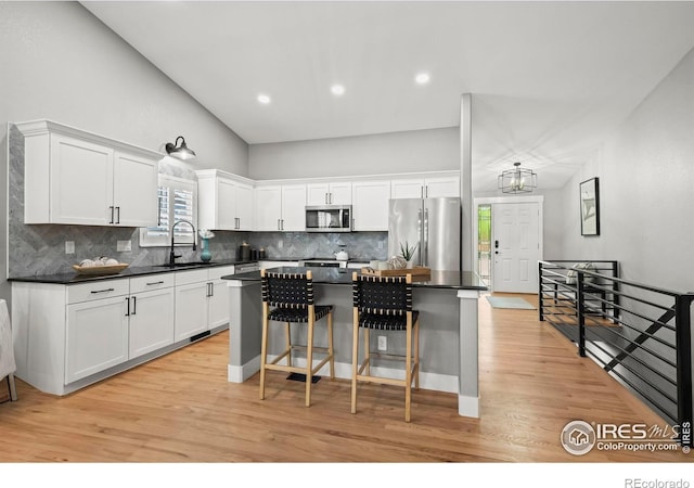 2384 Ponderosa Pl, Erie, CO 80516 - kitchen featuring stainless steel appliances, dark countertops, a center island, white cabinetry, and recessed lighting
