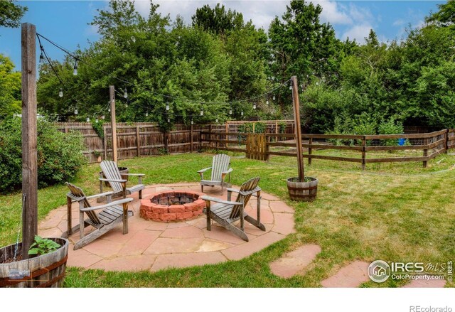 419 Centennial Dr, Louisville, CO 80027 - fenced backyard featuring an outdoor fire pit and a patio area