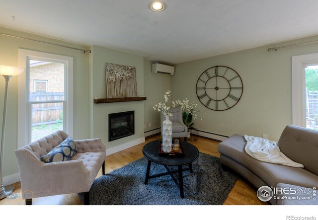 419 Centennial Dr, Louisville, CO 80027 - living room with a wall mounted air conditioner, a glass covered fireplace, wood finished floors, a baseboard radiator, and recessed lighting