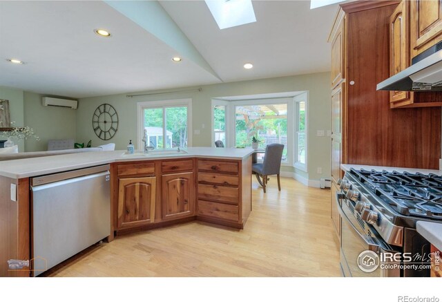 419 Centennial Dr, Louisville, CO 80027 - kitchen with appliances with stainless steel finishes, an AC wall unit, under cabinet range hood, light wood-style flooring, and light countertops